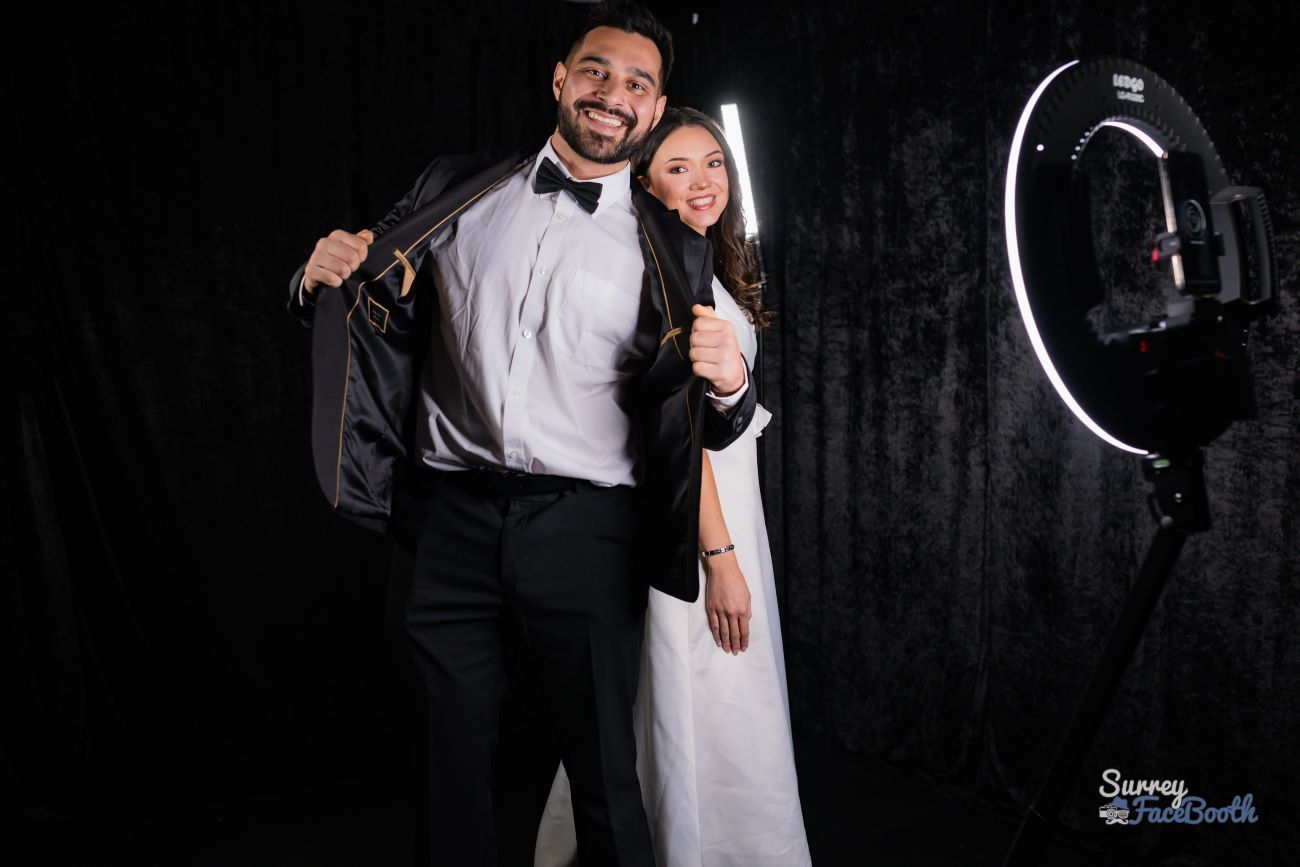 Bride and groom posing together on the 360 video booth platform with the ring light and rotating camera arm visible
